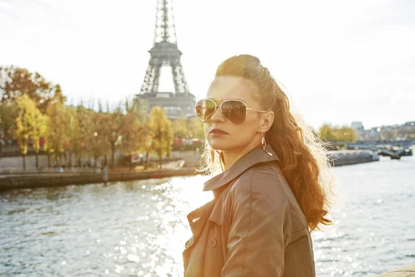 Donna in argine vicino alla torre Eiffel guardando in lontananza — Foto Stock