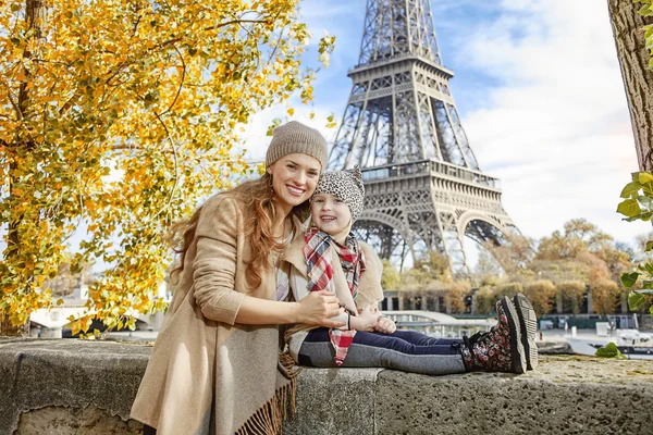 Mother and daughter travellers sitting on the parapet in Paris — Stock Photo, Image