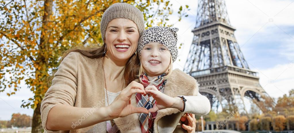 mother and daughter tourists in Paris showing heart shaped hands