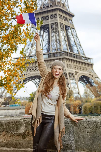 Smiling tourist woman on embankment in Paris, France rising flag — Stock Photo, Image