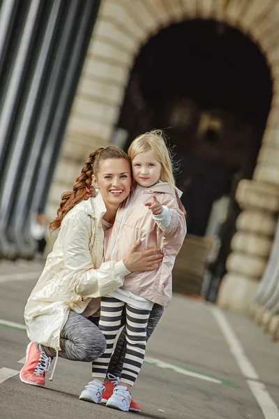 Healthy mother and daughter on bridge in Paris pointing in camer — Stock Photo, Image