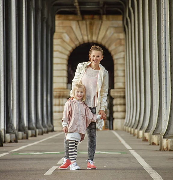 Aktiv mor og datter stående på Pont de Bir-Hakeim bro - Stock-foto