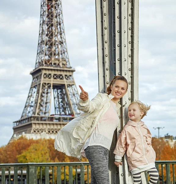 Aktivní matka a dítě ukazoval na něco blízko: Eiffel tower — Stock fotografie