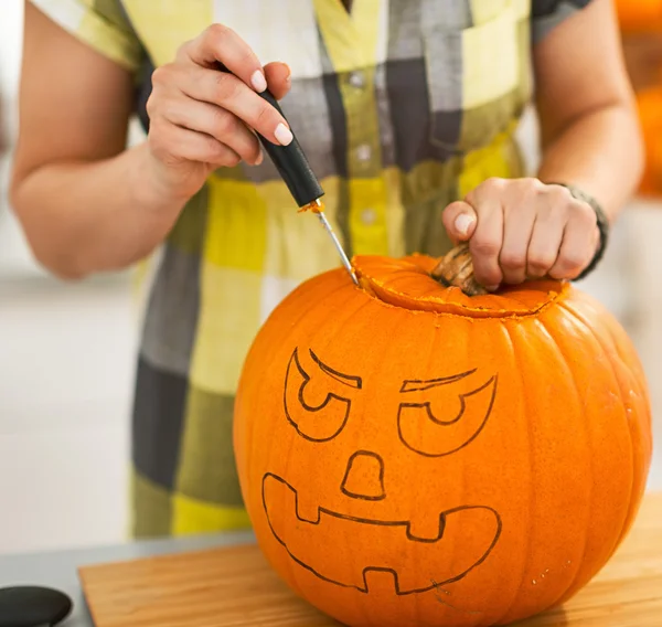 Closeup a háziasszony faragás egy nagy narancssárga sütőtök Jack-O-Lantern — Stock Fotó