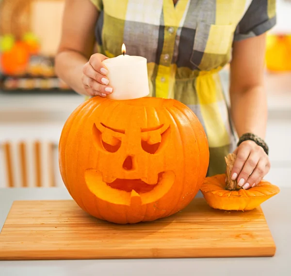 Primer plano de la mujer poniendo vela dentro de la calabaza Jack-O-Lantern —  Fotos de Stock