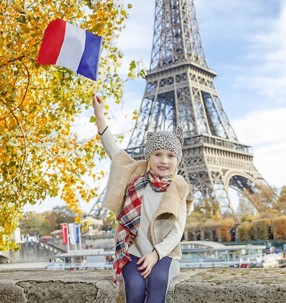 Elegante criança levantando bandeira enquanto sentado no parapeito em Paris — Fotografia de Stock