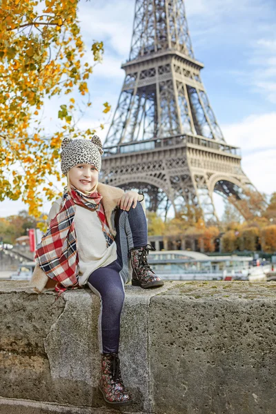 Elegante kind aan kade in Parijs zittend op de borstwering — Stockfoto