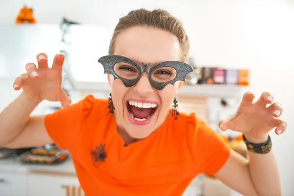 Smiling young woman in Halloween decorated kitchen frightening — Stock Photo, Image