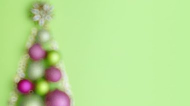 Mutlu noeller. Yeşil arka planda noel baloları ve noel ağacıyla yatıyordu. Bu video PRORes 422 kodlayıcısı ile yapılmış..