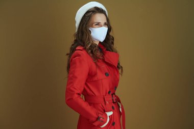 Merhaba sonbahar. Bronz arka planda kırmızı ceketli şık orta yaşlı kadın..