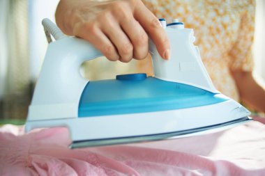 Güneşli bir günde evde demirli bir kadına yakın çekim..