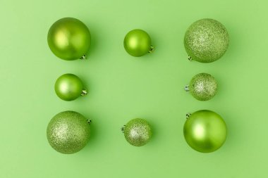 Mutlu noeller. Yeşil zemin üzerinde noel topları ile düz uzandı.