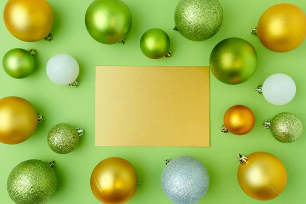 メリークリスマス 緑の背景に文字とクリスマスボールで平らなレイアウト — ストック写真