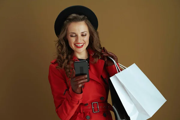 안녕하 코트를 베레모를 현대의 여성의 웃으며 장갑과 쇼핑백을 배경에 웃는다 — 스톡 사진
