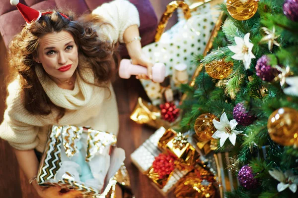 圣诞快乐 穿着金色亮片裙 头戴哑铃毛衣 头戴圣诞礼帽 头戴圣诞树和礼品盒的时髦女性的上图 — 图库照片
