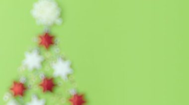 Mutlu noeller. Yeşil arka planda noel ağacı ve Noel oyuncaklarıyla yatıyordu. Bu video PRORes 422 kodlayıcısı ile yapılmış..