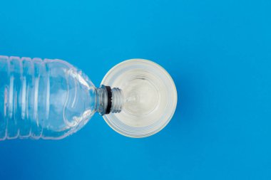 Plastik şişeden mavi arka planda cama akan suyla yatıyordu..