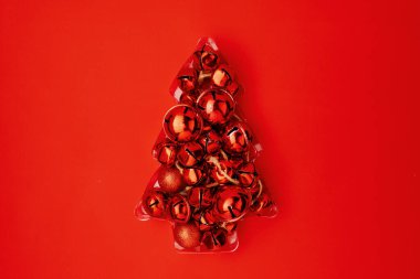 Kırmızı arka planda Noel ağacıyla bembeyaz uzanmış..