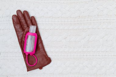 Beyaz örülmüş arka planda eldivenler ve dezenfektanla,.