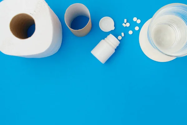 Flat Lay Toilet Paper Pills Glass Water Blue Background — Zdjęcie stockowe