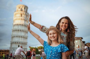 İtalya, Pisa 'daki Leaning Tower' da poz veren mutlu anne ve kız..