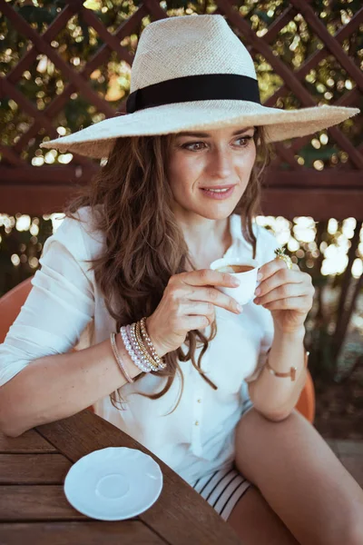 Pensive Moderne Huisvrouw Wit Shirt Met Kopje Koffie Hoed Zitten — Stockfoto