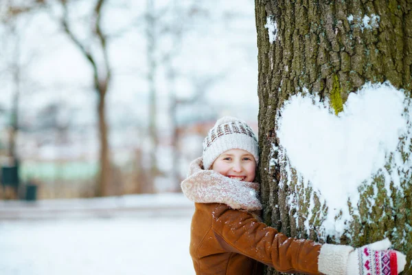 Šťastná Stylová Dívka Palčáky Pleteném Klobouku Ovčí Kožich Objímající Strom — Stock fotografie