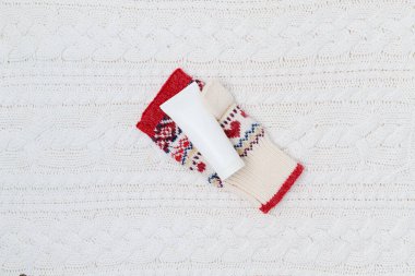 El kremi ve beyaz örgü arka planda eldivenler ile düz bir kış yatıyordu.