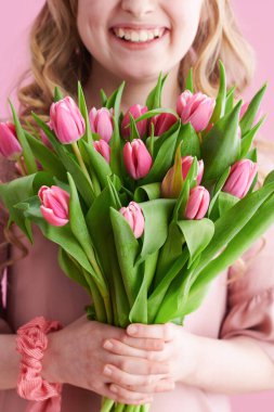 Uzun dalgalı sarı saçlı, pembe renkli lale buketli mutlu çocuğa yaklaş..