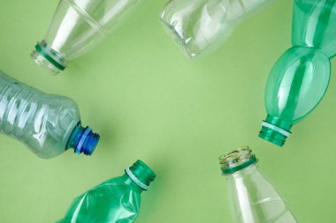 Yeşil zemin üzerinde plastik şişeler ile düz yatıyordu.