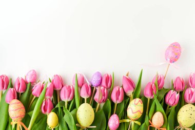 Beyaz arka planda izole edilmiş laleler ve paskalya yumurtaları ile bembeyaz yatıyordu.