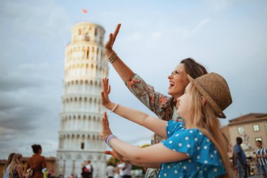 İtalya, Pisa 'daki Leaning Tower' da poz veren mutlu moda aile.
