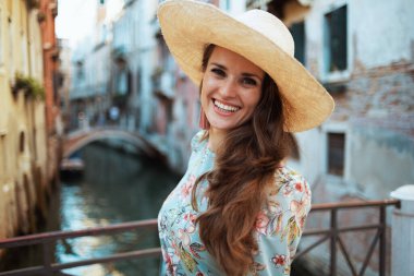 Venedik, İtalya 'da şapkasıyla gezintiye çıkan çiçekli elbiseli, son moda yalnız turist kadının portresi..