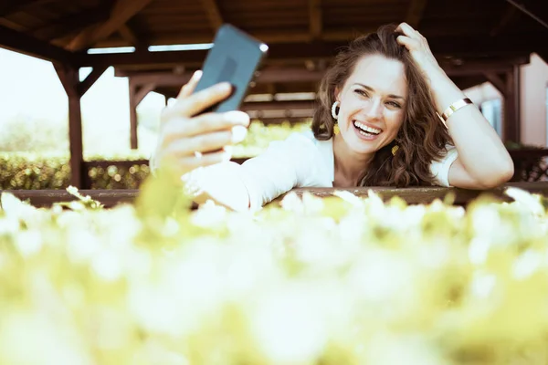 셔츠를 목장에서 스마트폰으로 온라인 미팅을 여성에게 미소짓습니다 — 스톡 사진