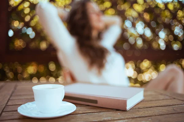Großaufnahme Bei Kaffee Und Buch Tisch Und Entspannte Frau Hintergrund — Stockfoto