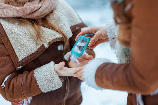 Closeup Mother Daughter Hats Sheepskin Coats Disinfecting Hands Sanitiser Outdoors — Stock Photo, Image