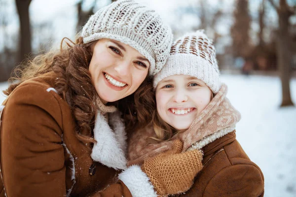 겨울에 공원에서는 모자를 양가죽 코트를 어머니와 아이의 — 스톡 사진