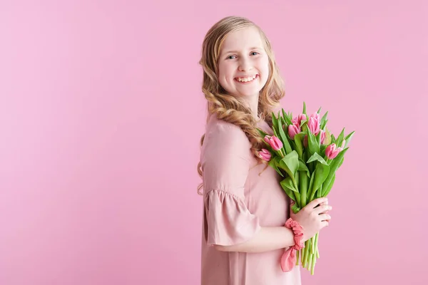 スタイリッシュな子供とともに長い波状ブロンド髪とともにチューリップ花束にピンクの背景 — ストック写真