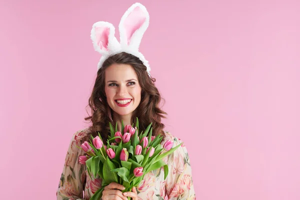 若いです女性とともに長い波状ブルネットの髪でチューリップ花束とウサギの耳ピンクの上に隔離 — ストック写真