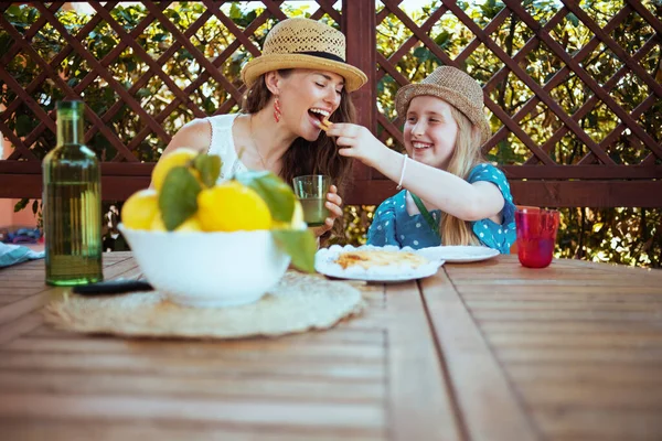 손님이 호텔의 뜰에서 브런치를 식탁에 접시와 레모네이드를 현대인 어머니와 딸에게 — 스톡 사진