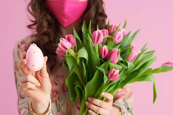 带有郁金香花束 粉色面罩和粉色背景的复活节彩蛋的女人的衣服 — 图库照片