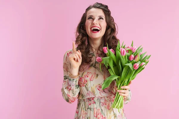 笑着的现代女性 有着长长的波浪般的黑发 郁金香花束 与粉色隔离在一起 — 图库照片