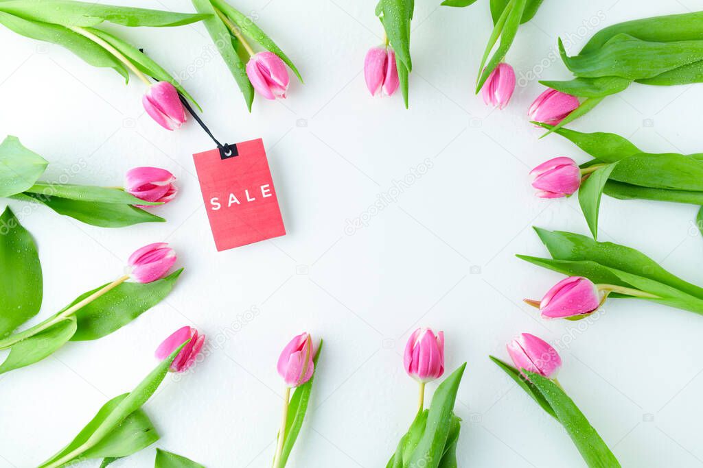 spring flat lay with sale label and tulips isolated on white.