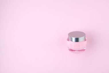 Pembe arka planda yüz kremi izole bir şekilde yatıyordu..