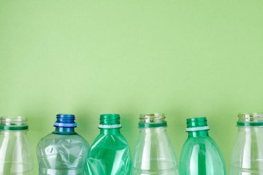 Yeşil üzerine izole edilmiş plastik şişelerle yatıyordu..