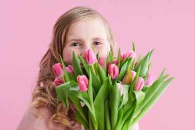 Uzun dalgalı sarı saçlı, lale buketli, pembe tenli modern çocuk..