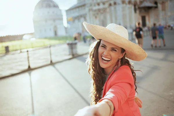 スタイリッシュな女性を笑顔で花のドレスに帽子で観光スポットを探索ボーイフレンドとともにピサ大聖堂近く — ストック写真