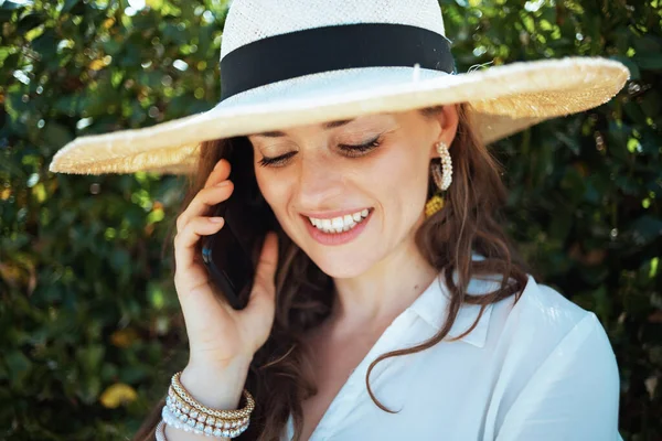 Glimlachende Stijlvolle Vrouw Wit Shirt Met Hoed Spreken Een Smartphone — Stockfoto