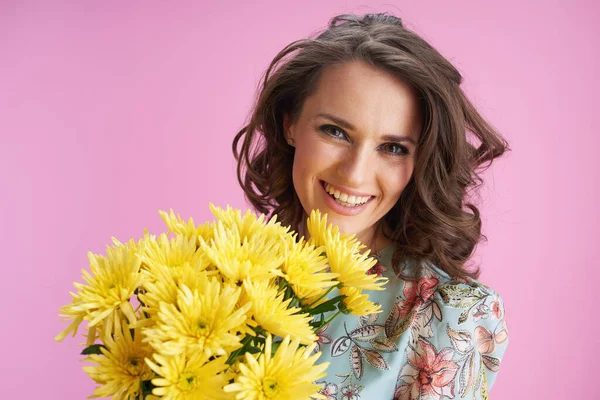 ピンクに隔離された黄色の菊の花と花のドレスで幸せなエレガントな女性の肖像 — ストック写真
