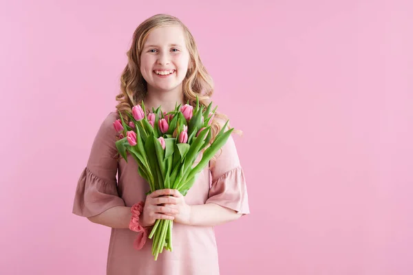 穿着粉红衣服 背景为粉色的郁金香花束的快乐的时髦女孩 — 图库照片